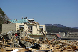 震災直後の陸前高田市。屋根の上に乗っかっているトラック。津波の高さを物語っています。